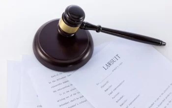 A gavel on top of papers that read "lawsuit"